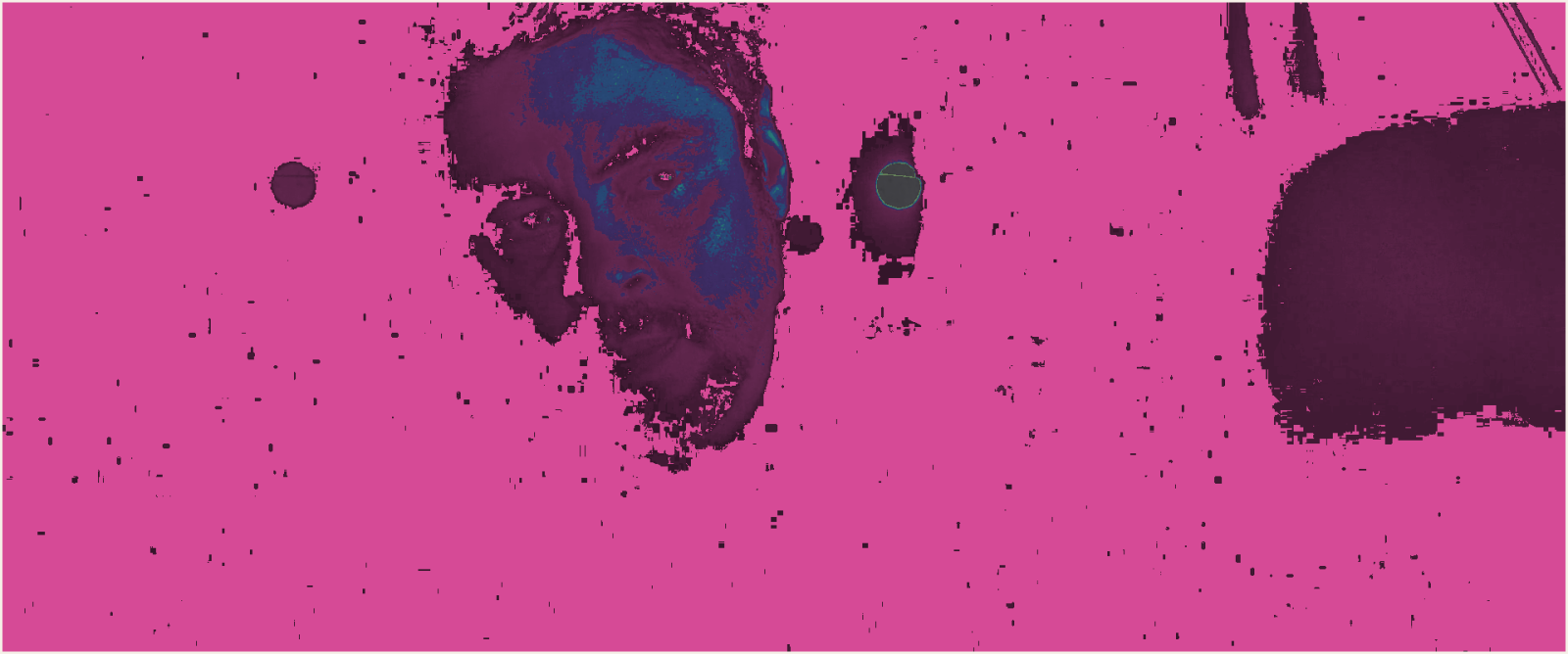 A map of the same frame, the great majority painted flat magenta for pixels at absolute zero, with the face and two lights picked out.