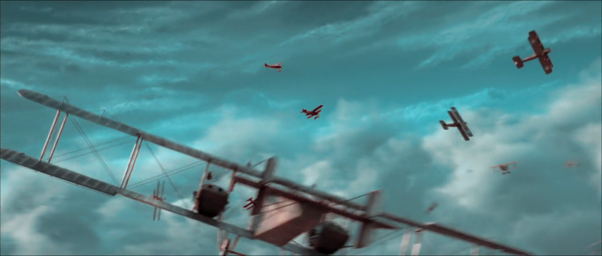 A large grey biplane bomber tilted steeply across the lower frame, several small red-brown biplanes flying around it, all against a turquoise sky filled with streaked grey cloud.