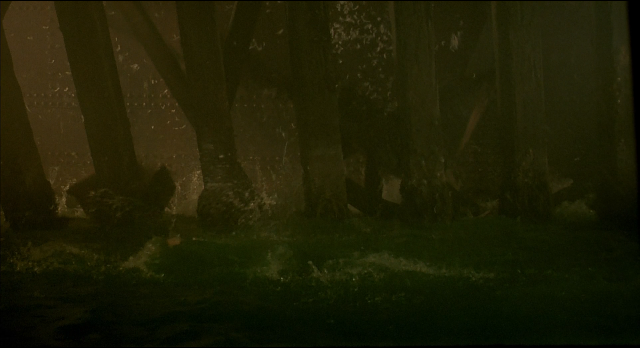 Dim vertical industrial structures barely visible through murky green fog.