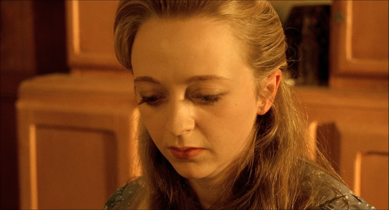 Close-up of a woman in warm brown and ochre light.