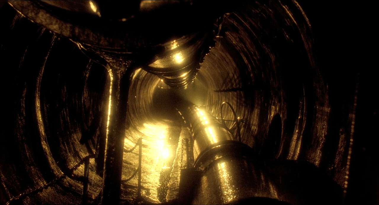 A dark circular tunnel converging on a small brilliant amber light.